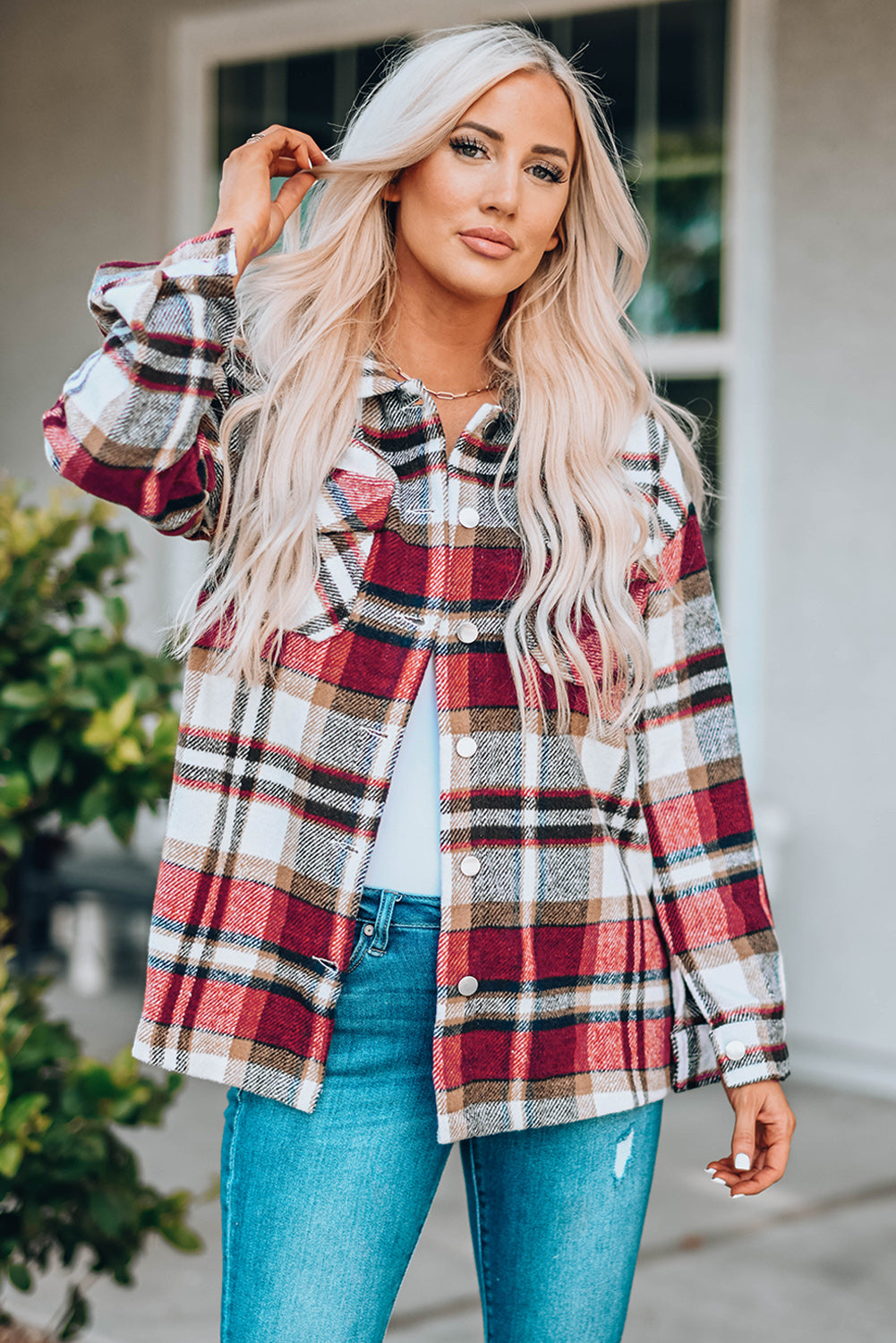 Woman wearing a plaid shirt and blue jeans outdoors
