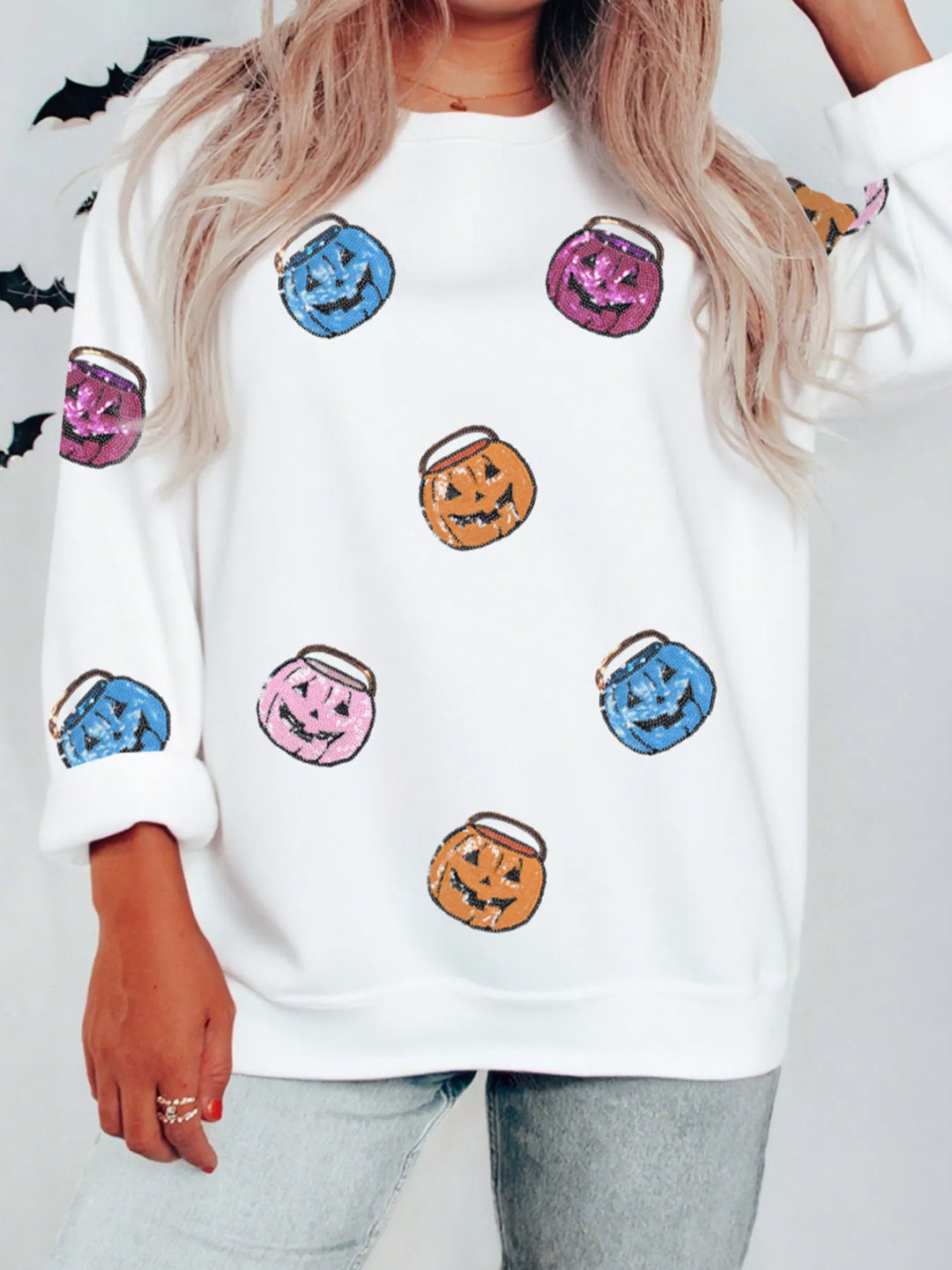 Women wearing a white sweatshirts with blue purple orange and pink small  Halloween buckets