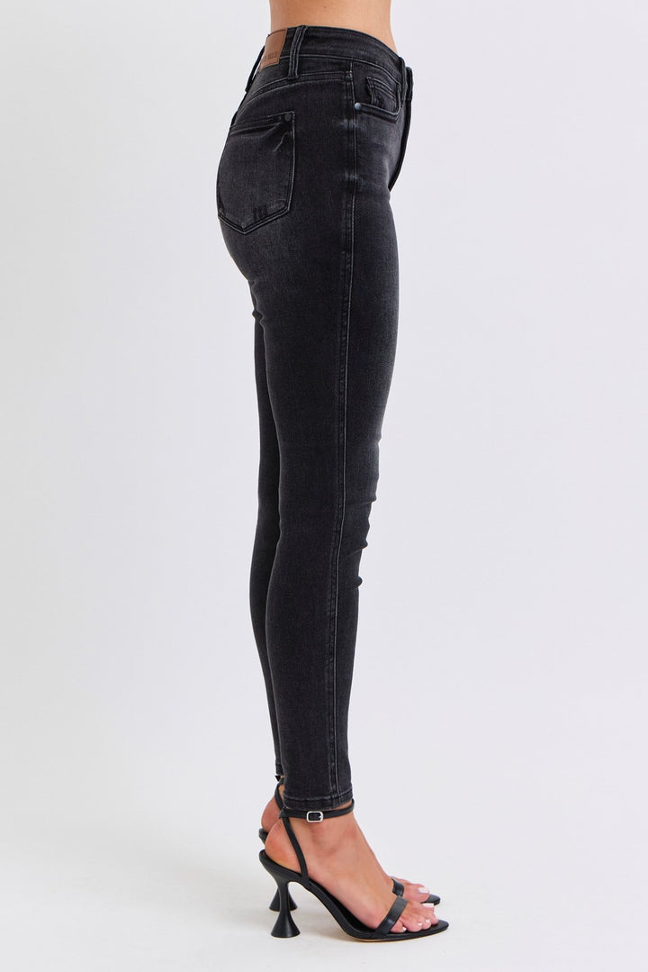 Woman wearing black skinny jeans with white background. Judy Blue Jeans (NP) - Mid Rise Tummy Control Skinny - black | Nikki &amp; Co. Boutique