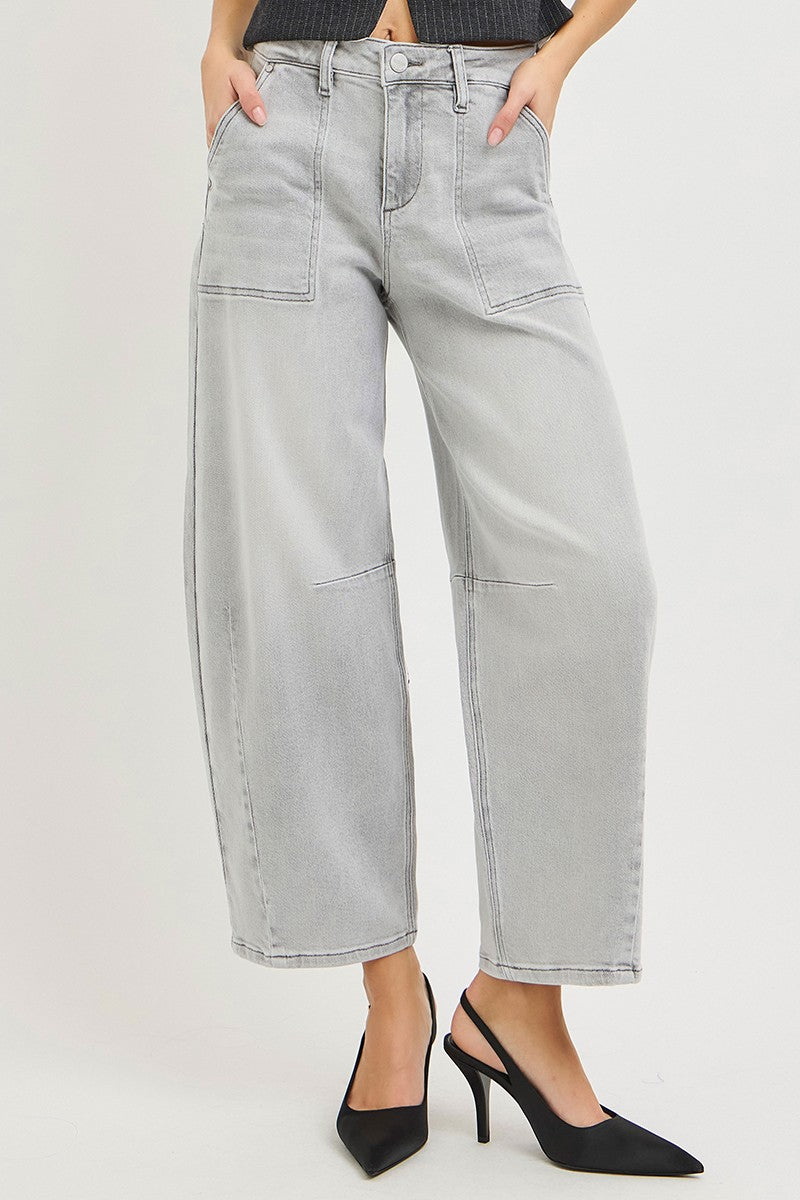 Person wearing light gray jeans and black high-heeled shoes on a white background