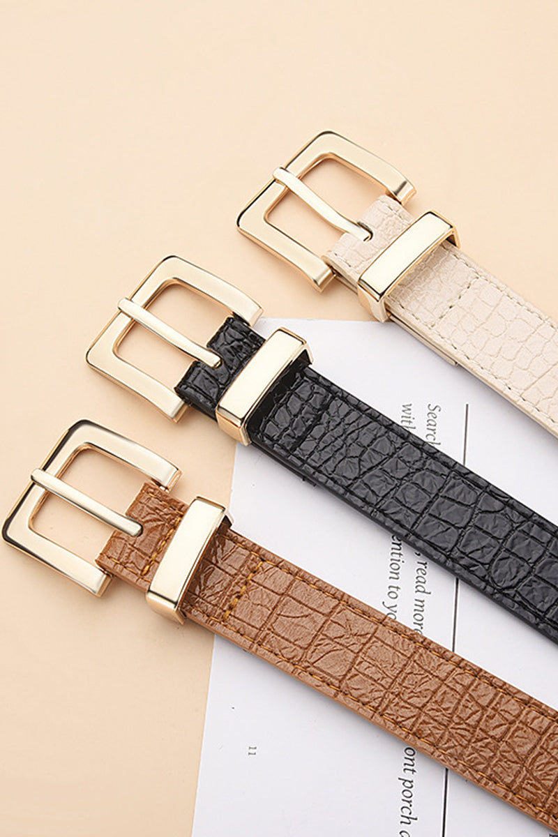 Three leather belts with gold buckles on a beige background