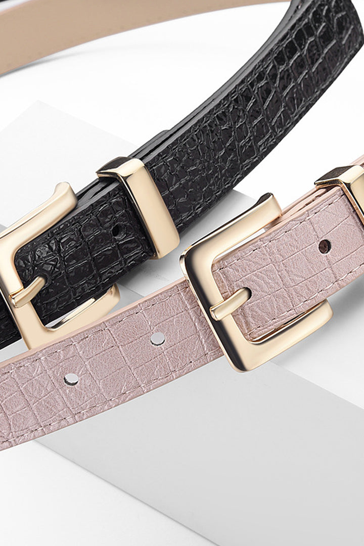 Two belts, one black and one pink, with gold buckles on a light background.