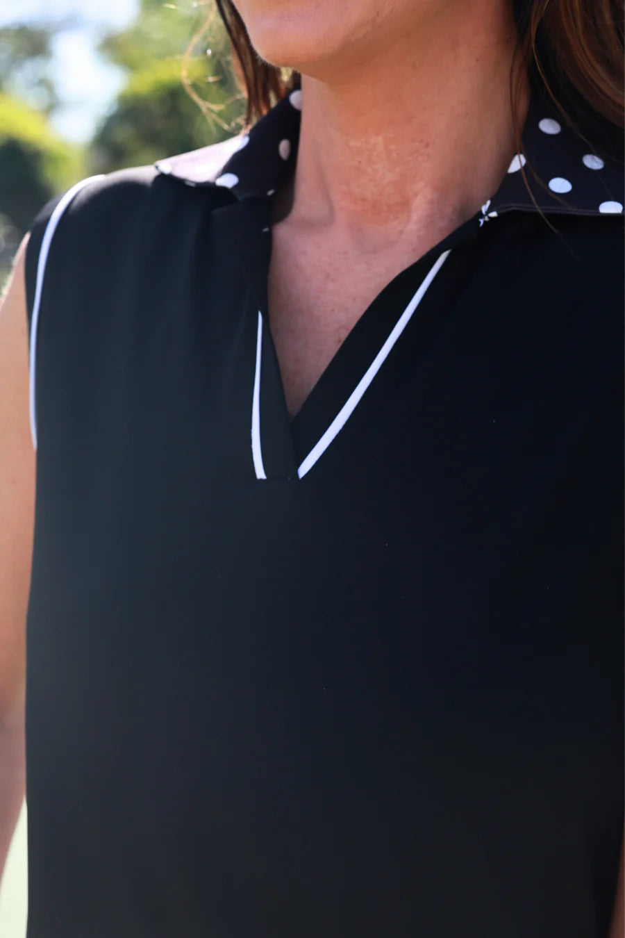 Black sleeveless top with white polka dot collar and trim
