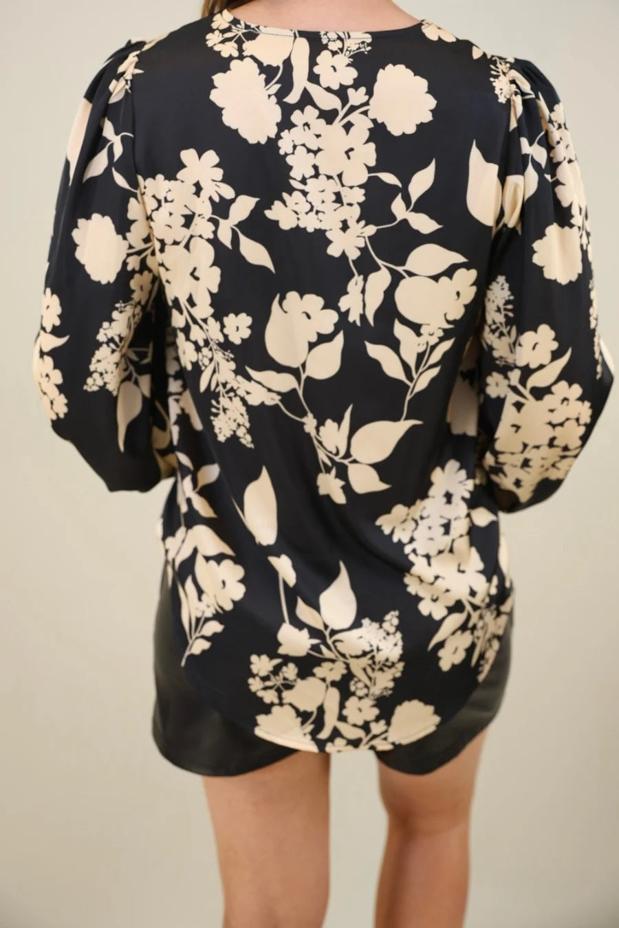 Back view of a black floral blouse and shorts