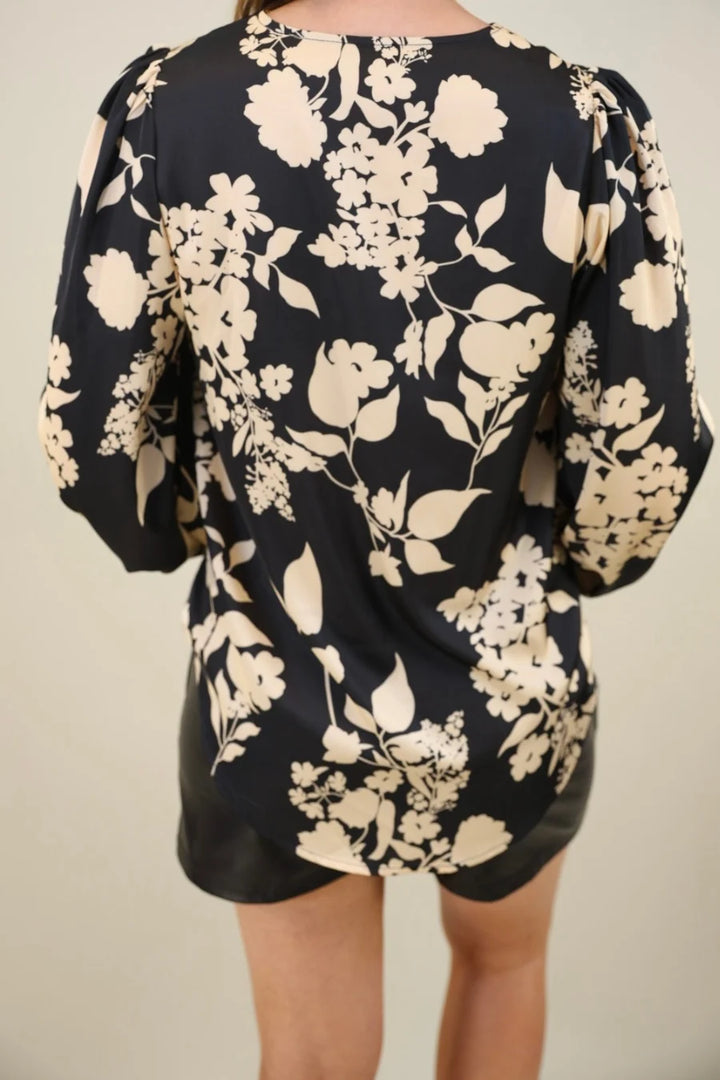 Back view of a black floral blouse and shorts