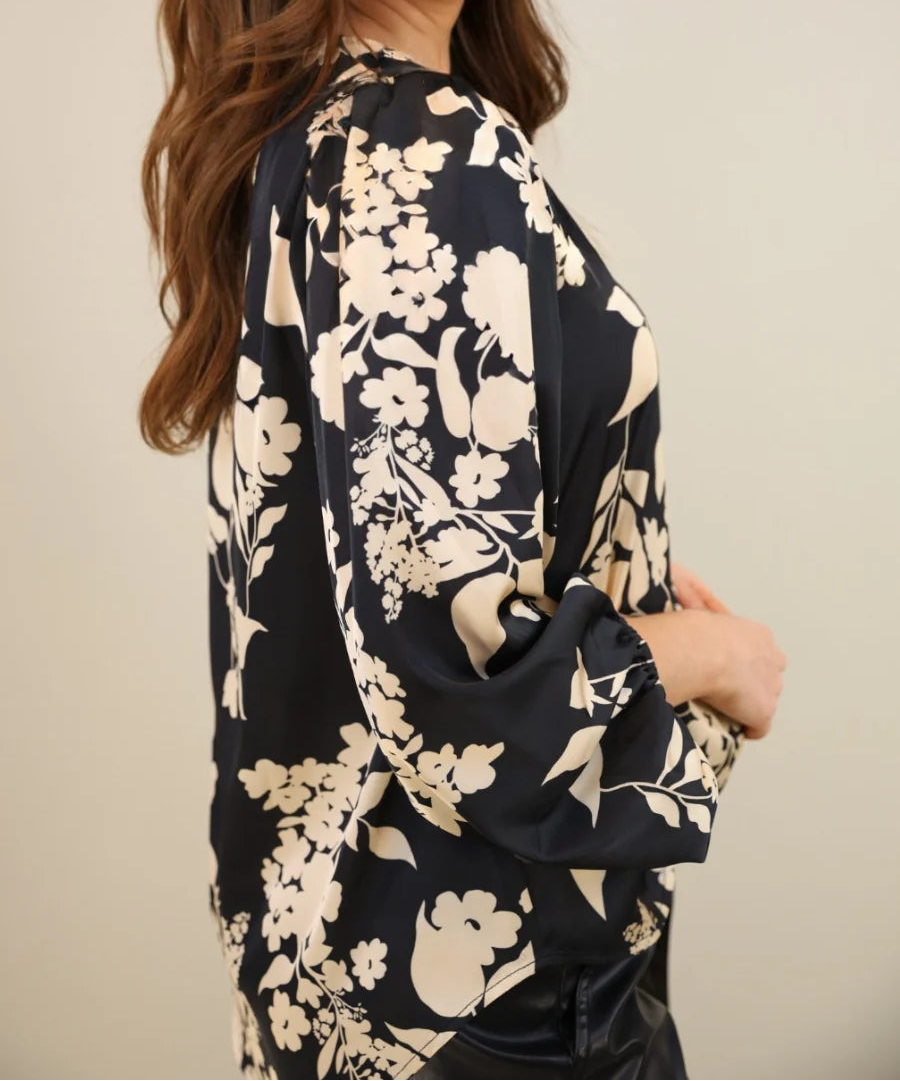 Women posing in a black floral blouse