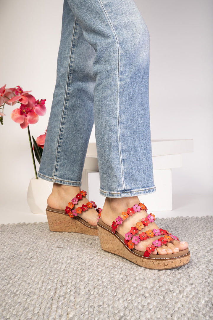 Person wearing colorful sandals with a neutral background