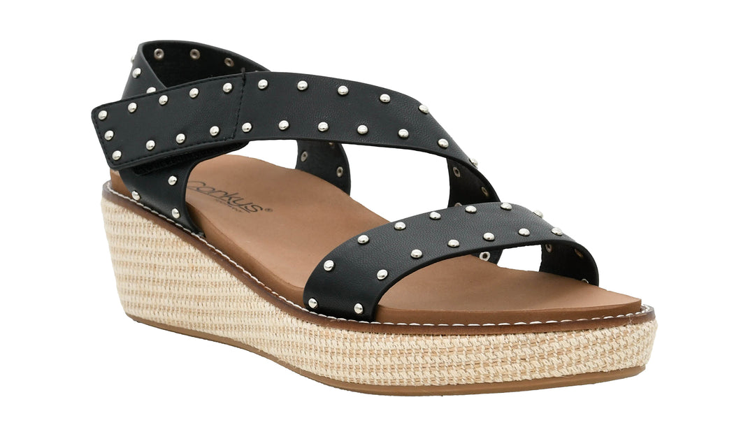 Black wedge sandal with studded details on a white background