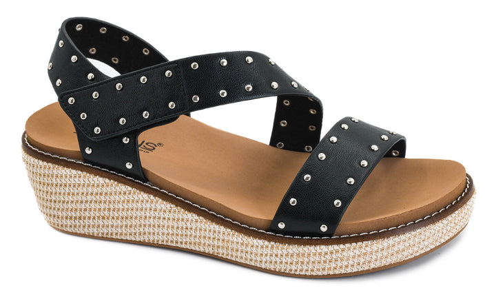 Black wedge sandal with studded details on a white background