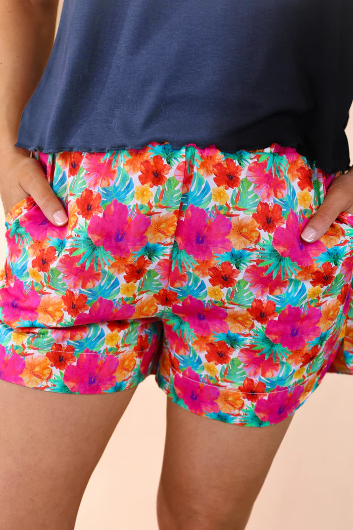 Colorful floral shorts worn by a person against a neutral background