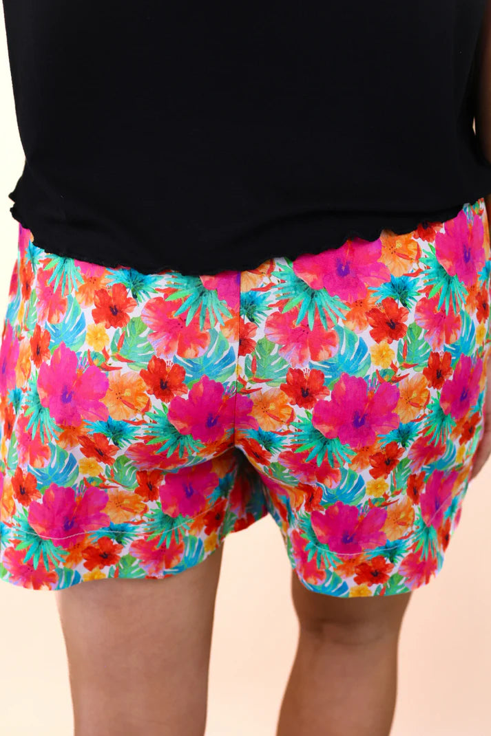 Colorful floral shorts worn by a person against a neutral background