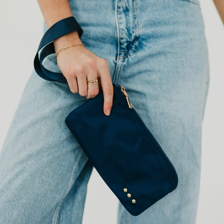 Person holding a navy wristlet wallet