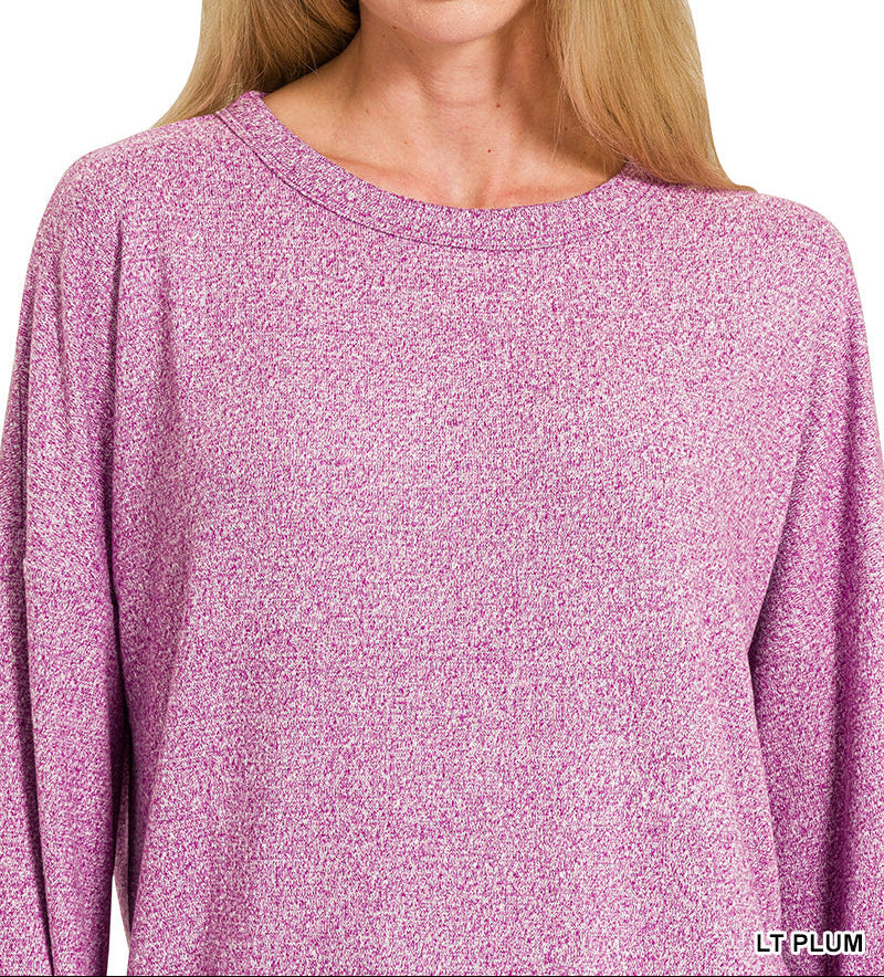 Woman wearing a light plum top with a round neckline