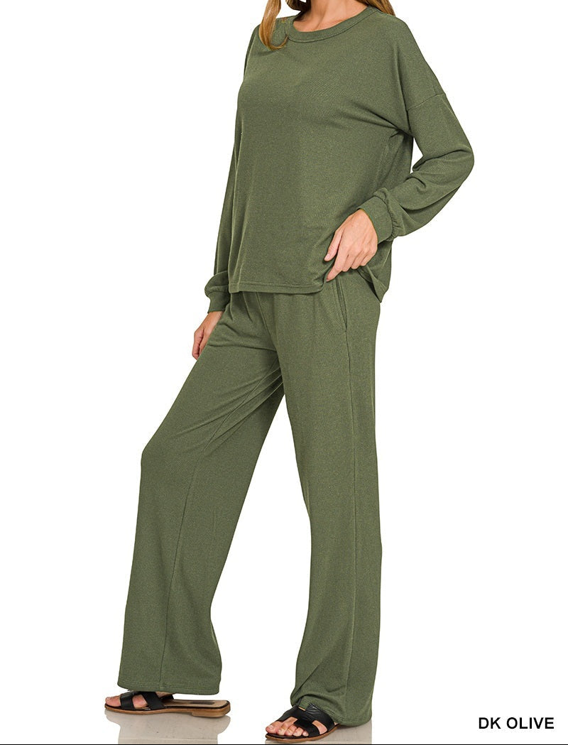 A woman modeling a matching olive green lounge set consisting of a long-sleeve top and wide-leg pants, shown against a plain white background with text overlays reading &