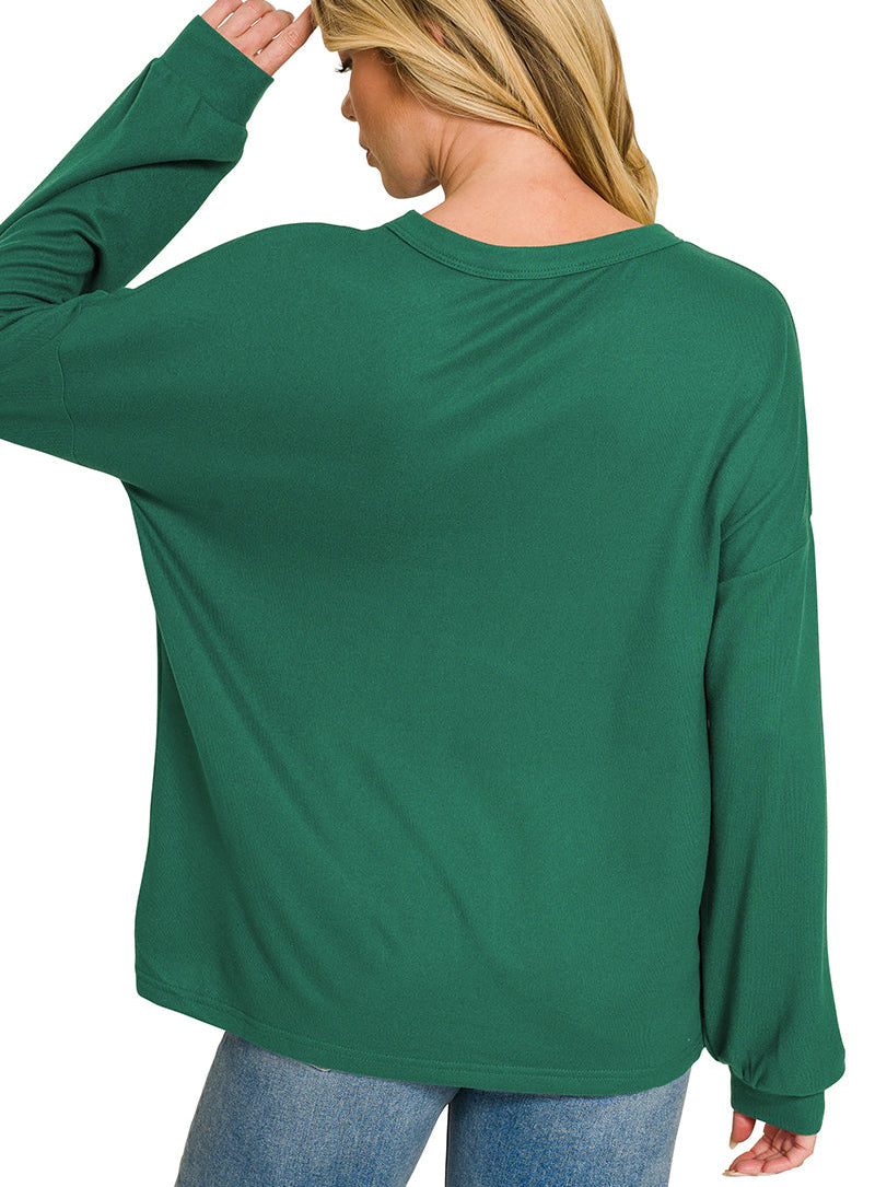 A woman shown from the back wearing a long-sleeve crewneck top in hunter green, paired with blue jeans, against a plain white background.