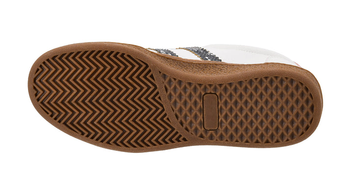 Close-up of a brown sole with a white and black patterned shoe above it on a white background