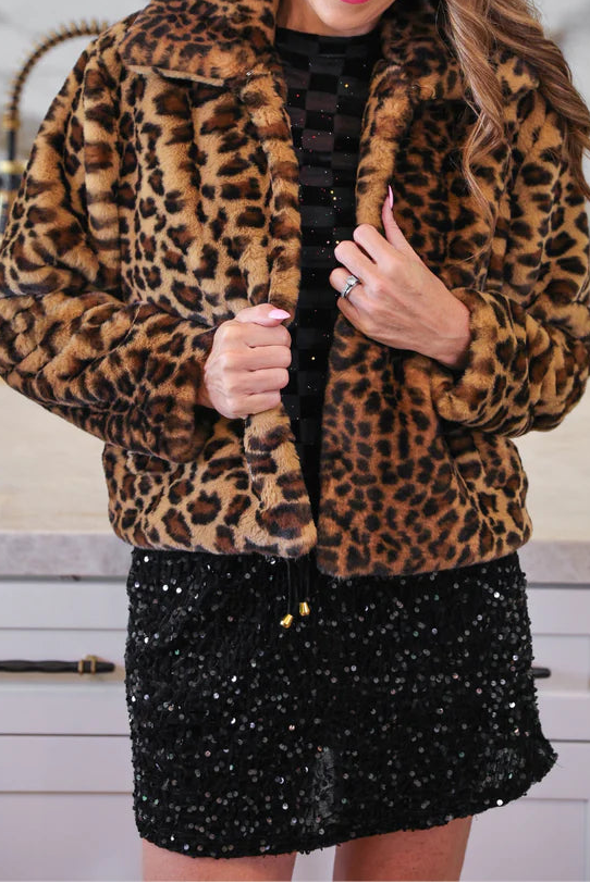 Woman wearing a leopard print jacket in a kitchen setting