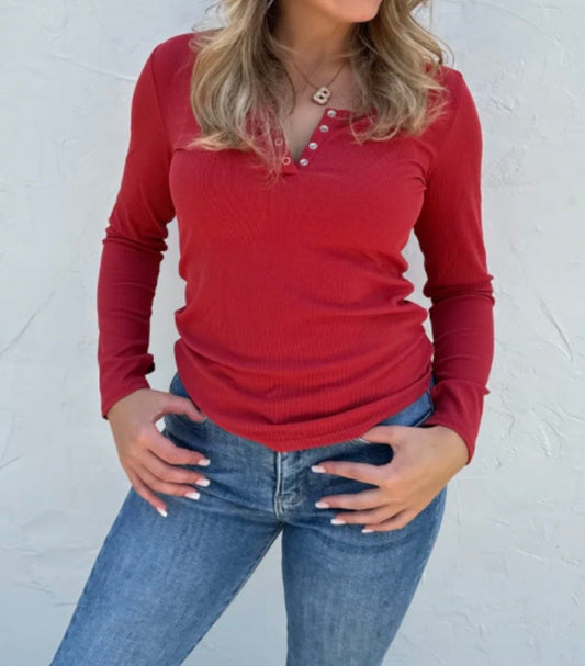 Person wearing a red long-sleeve top and blue jeans against a white background