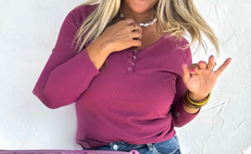 Woman wearing a purple long-sleeve top against a white background