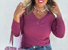 Woman wearing a purple long-sleeve top against a white background