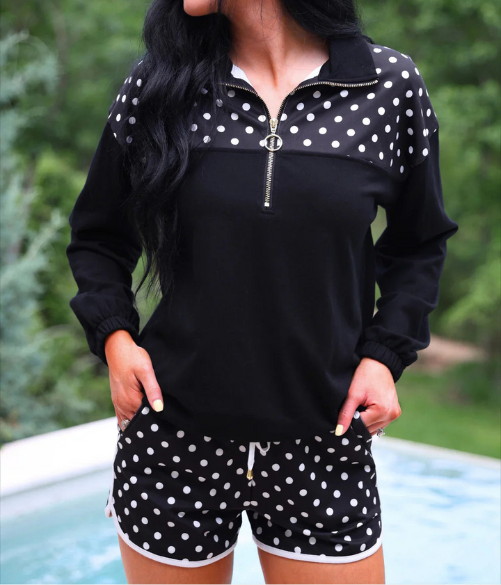 Woman wearing a black and white polka dot outfit by a pool