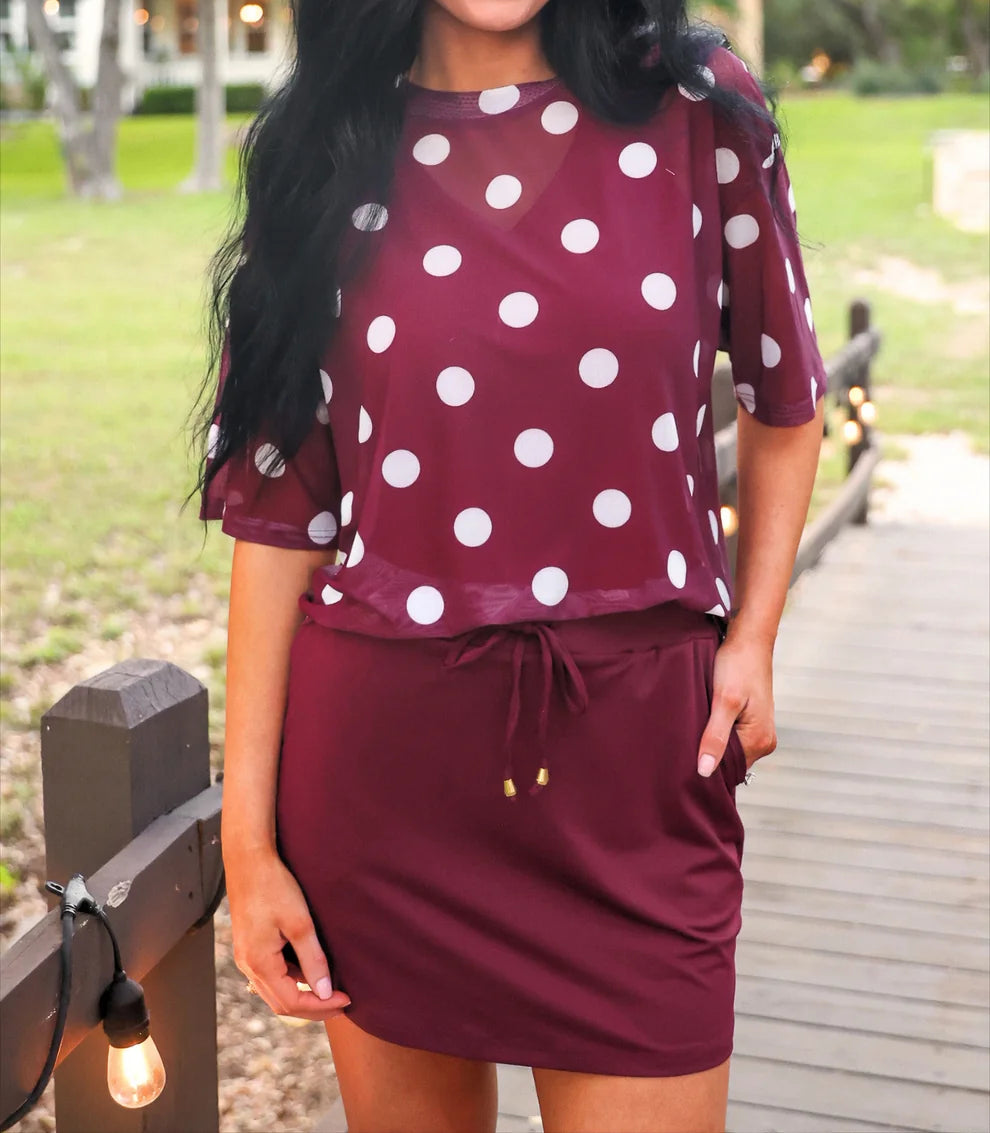 Woman wearing a burgundy skort with white polka dots in an outdoor setting