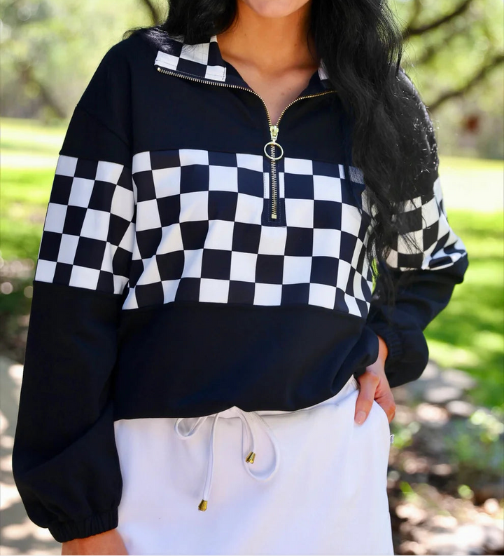 Woman wearing a black and white checkered jacket outdoors
