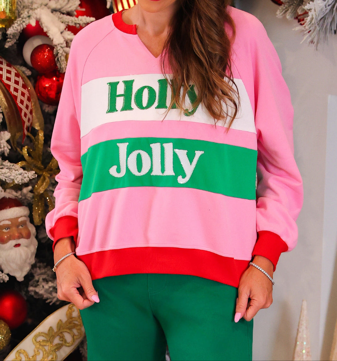A woman wearing a pink crewneck sweatshirt with &
