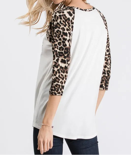 Woman wearing a white baseball shirt with leopard print sleeves on a white background