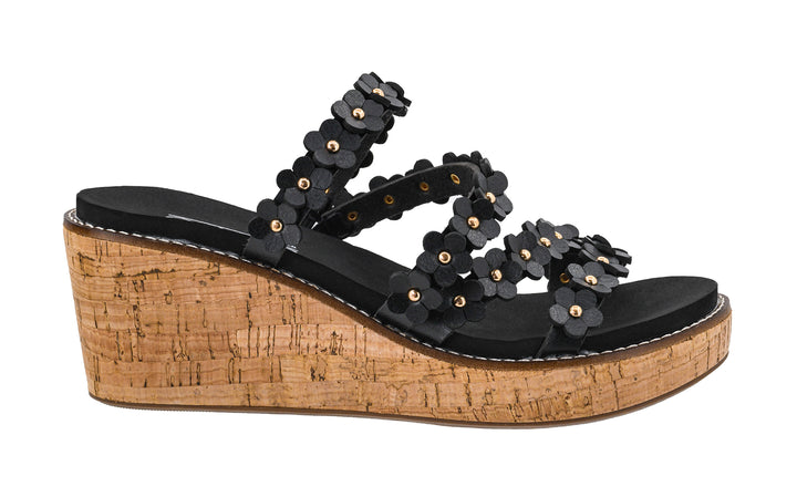 Black wedge sandal with floral decorations on a cork platform against a white background