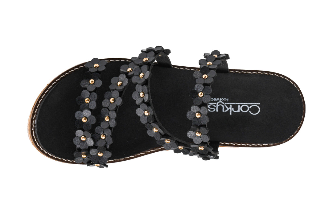 Black sandals with floral embellishments on a white background
