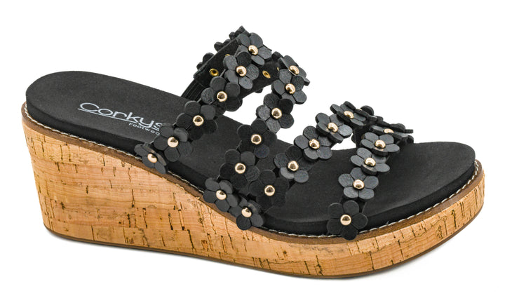 Black wedge sandal with floral decorations on a white background