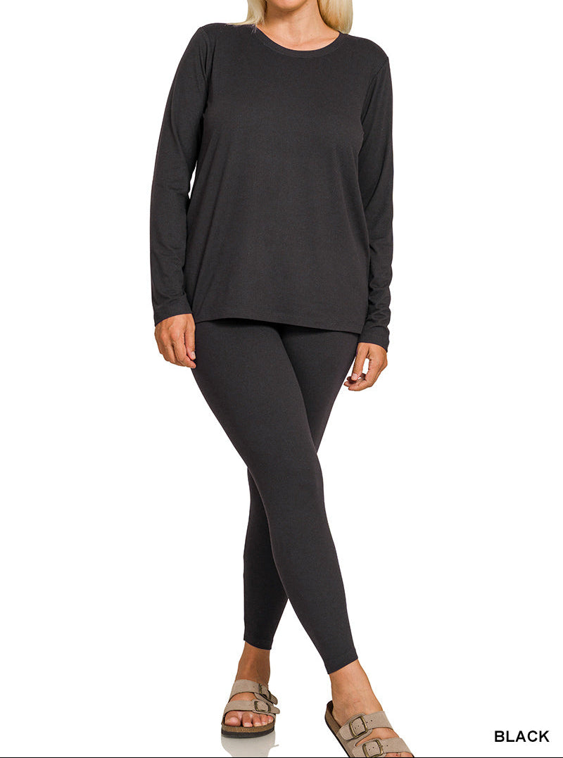 Woman wearing a black long-sleeve top and leggings on a white background