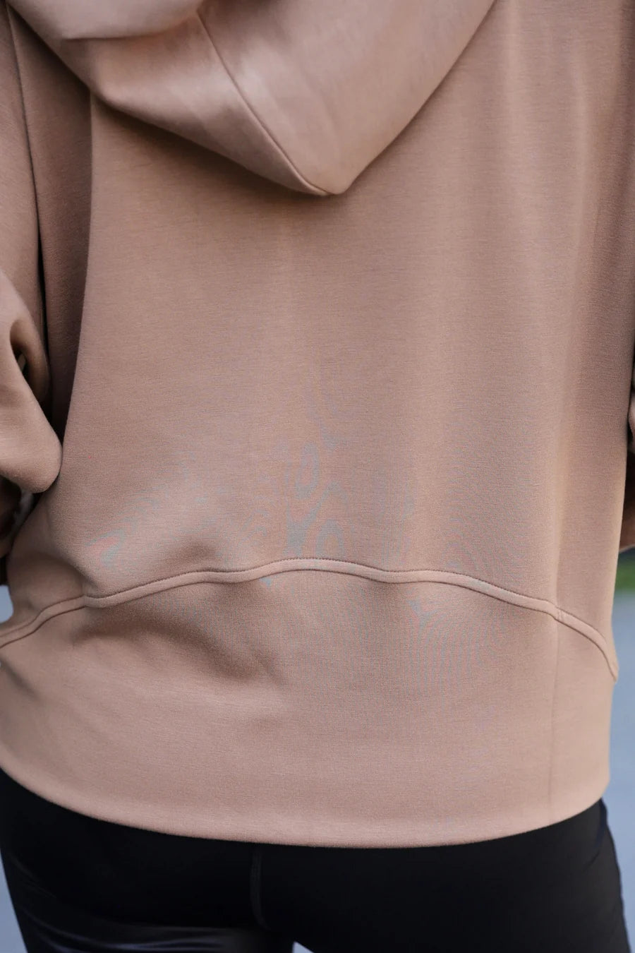 Close-up of a mocha brown hoodie with a blurred background