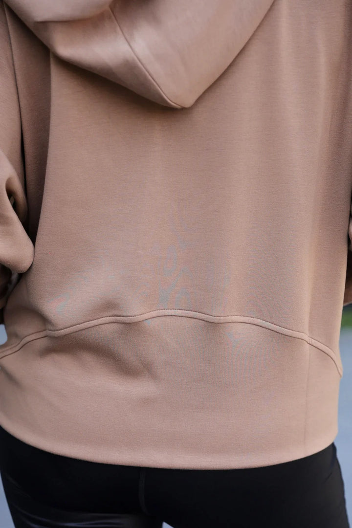 Close-up of a mocha brown hoodie with a blurred background