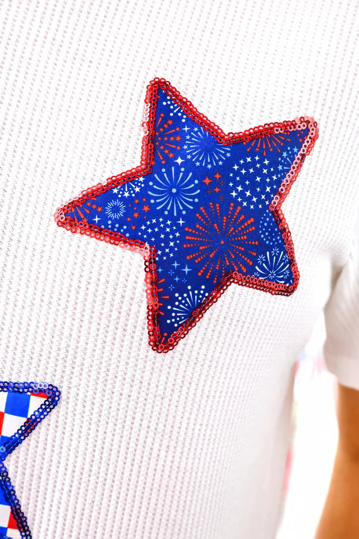 Star-shaped patch with blue and red design on a white sweater