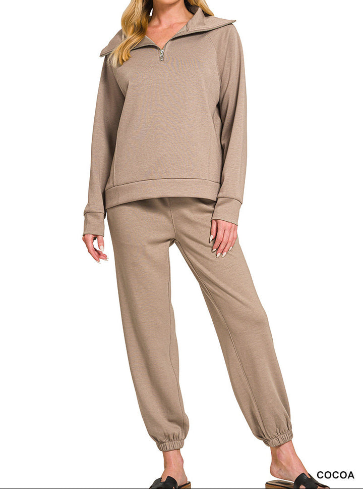 Woman wearing 2-piece set half zip top and pants gathered at the bottom