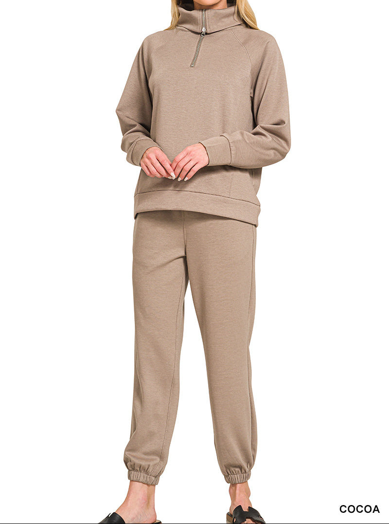 Woman wearing 2-piece set half zip top and pants gathered at the bottom