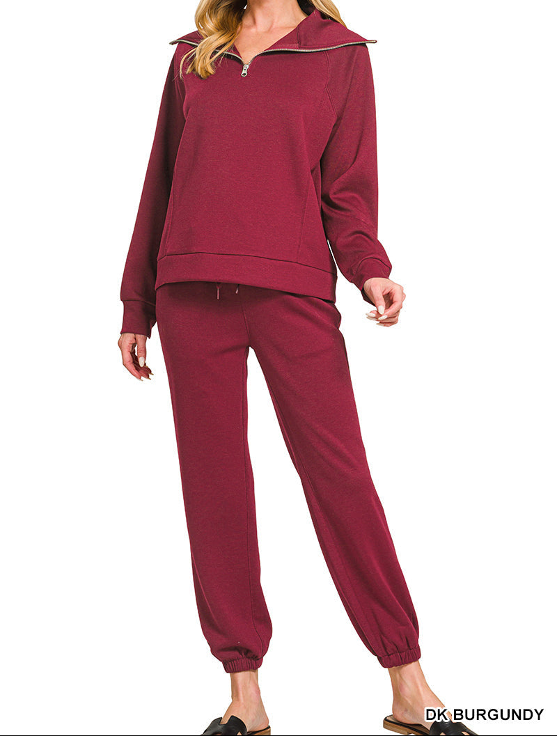 Woman wearing 2-piece set half zip top and pants gathered at the bottom