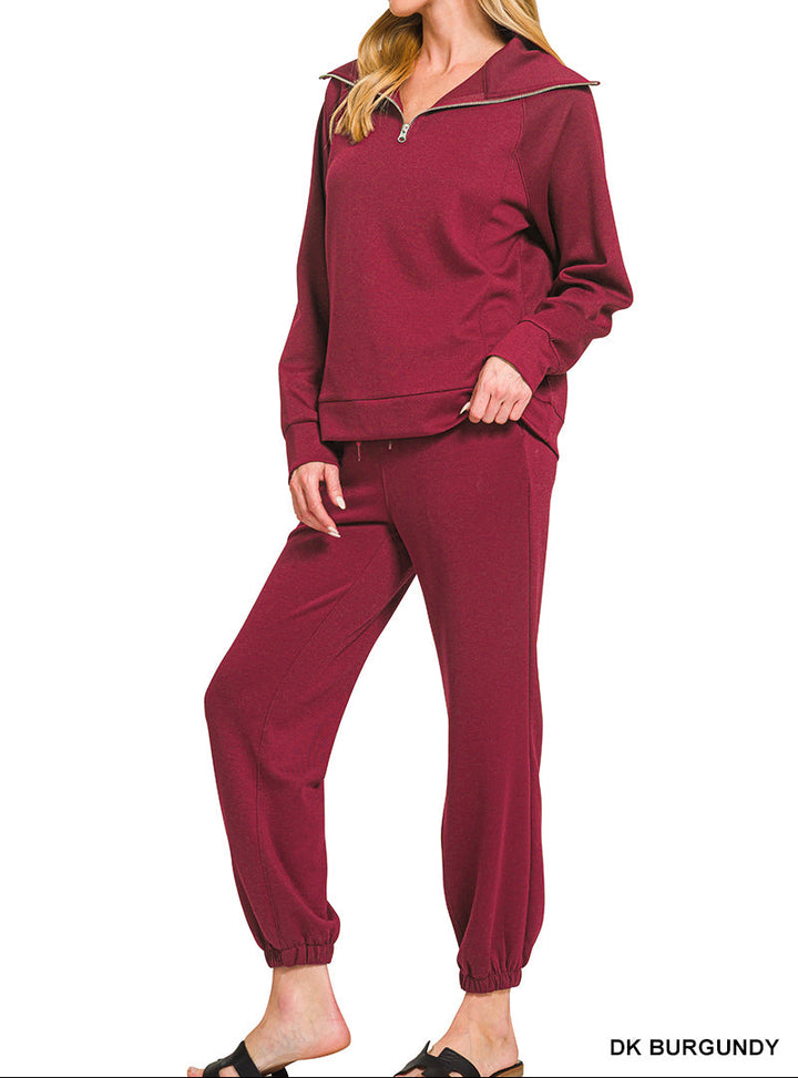 Woman wearing 2-piece set half zip top and pants gathered at the bottom