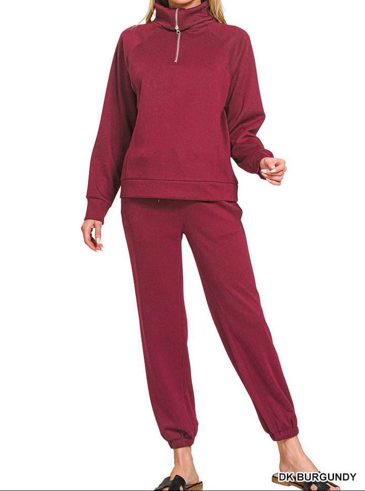 Woman wearing 2-piece set half zip top and pants gathered at the bottom