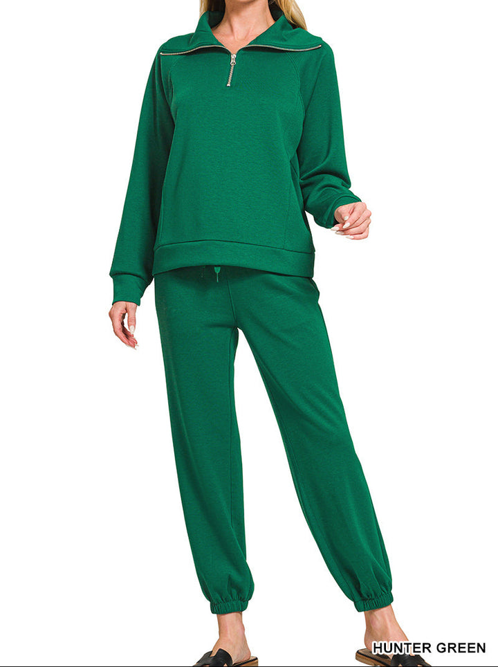 Woman wearing 2-piece set half zip top and pants gathered at the bottom