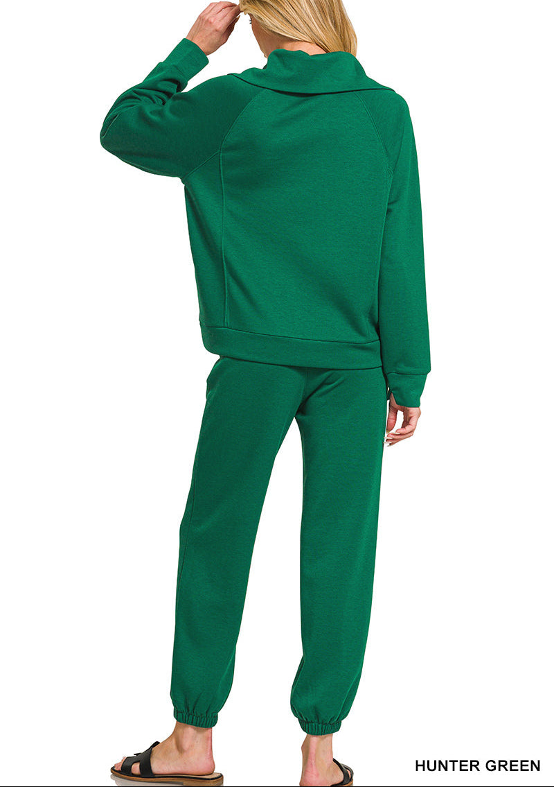 Woman wearing 2-piece set half zip top and pants gathered at the bottom