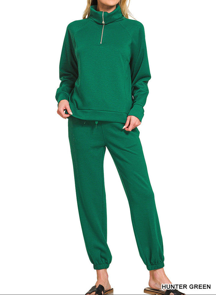 Woman wearing 2-piece set half zip top and pants gathered at the bottom