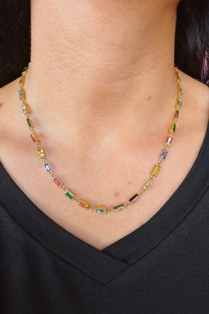 Woman wearing a colorful, gem necklace.