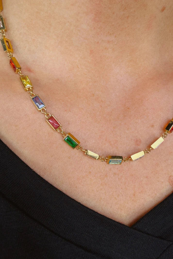Woman wearing a colorful, gem necklace.