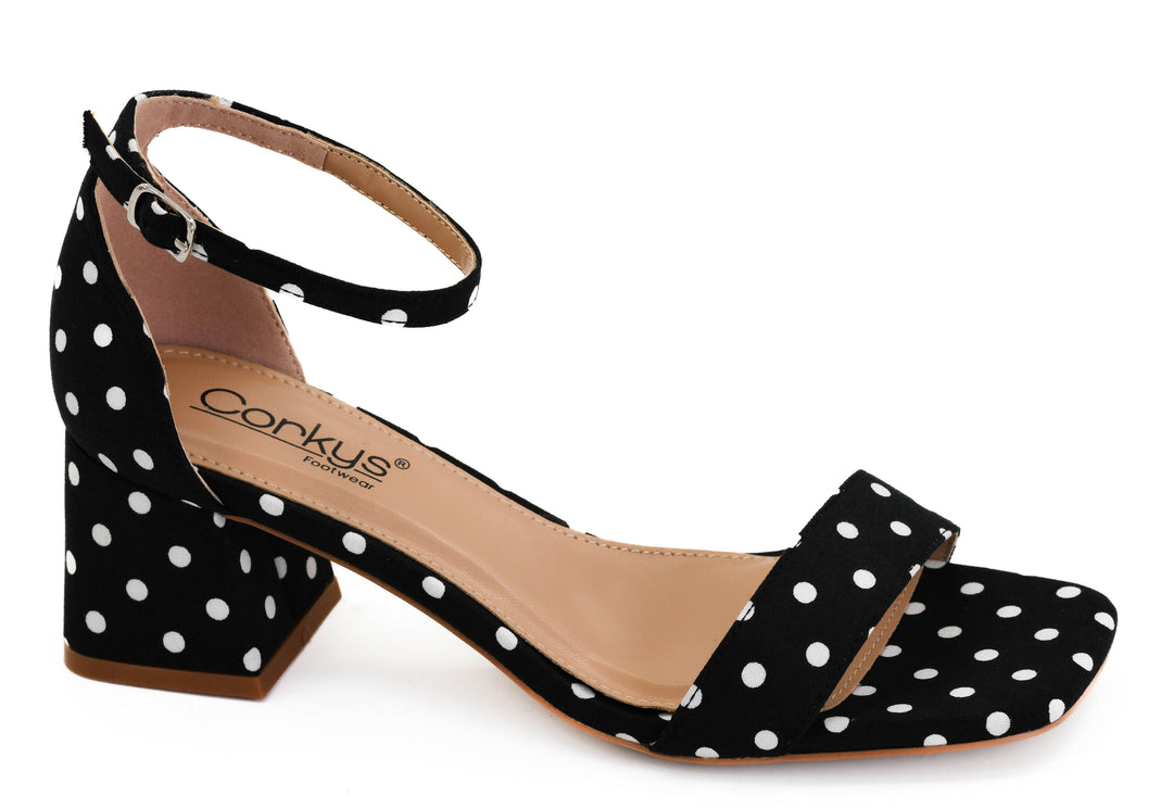 Black sandal with white polka dots on a white background