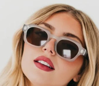 Woman wearing sunglasses with a plain background