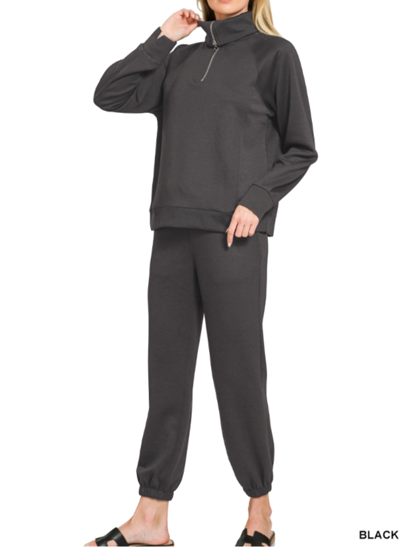 Woman wearing 2-piece set half zip top and pants gathered at the bottom