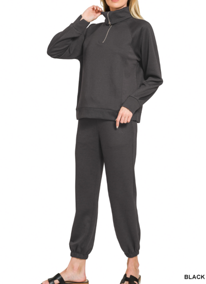 Woman wearing 2-piece set half zip top and pants gathered at the bottom